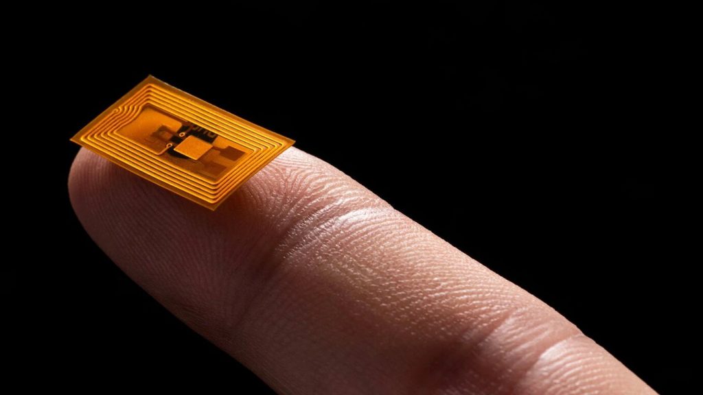Imagen que muestra un chip NFC para móvil en la yema de una dedo índice